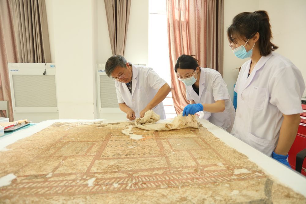 杨文宗（左一）和同事在对《门楼图》壁画进行修复（受访者供图）