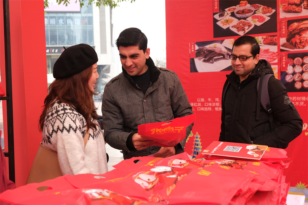 活动现场,外籍留学生正在咨询张鸭子食品情况。石楚园 摄