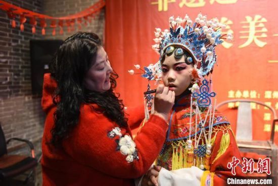 1月31日，老师在为“小演员”化妆换戏服。刘娟 摄