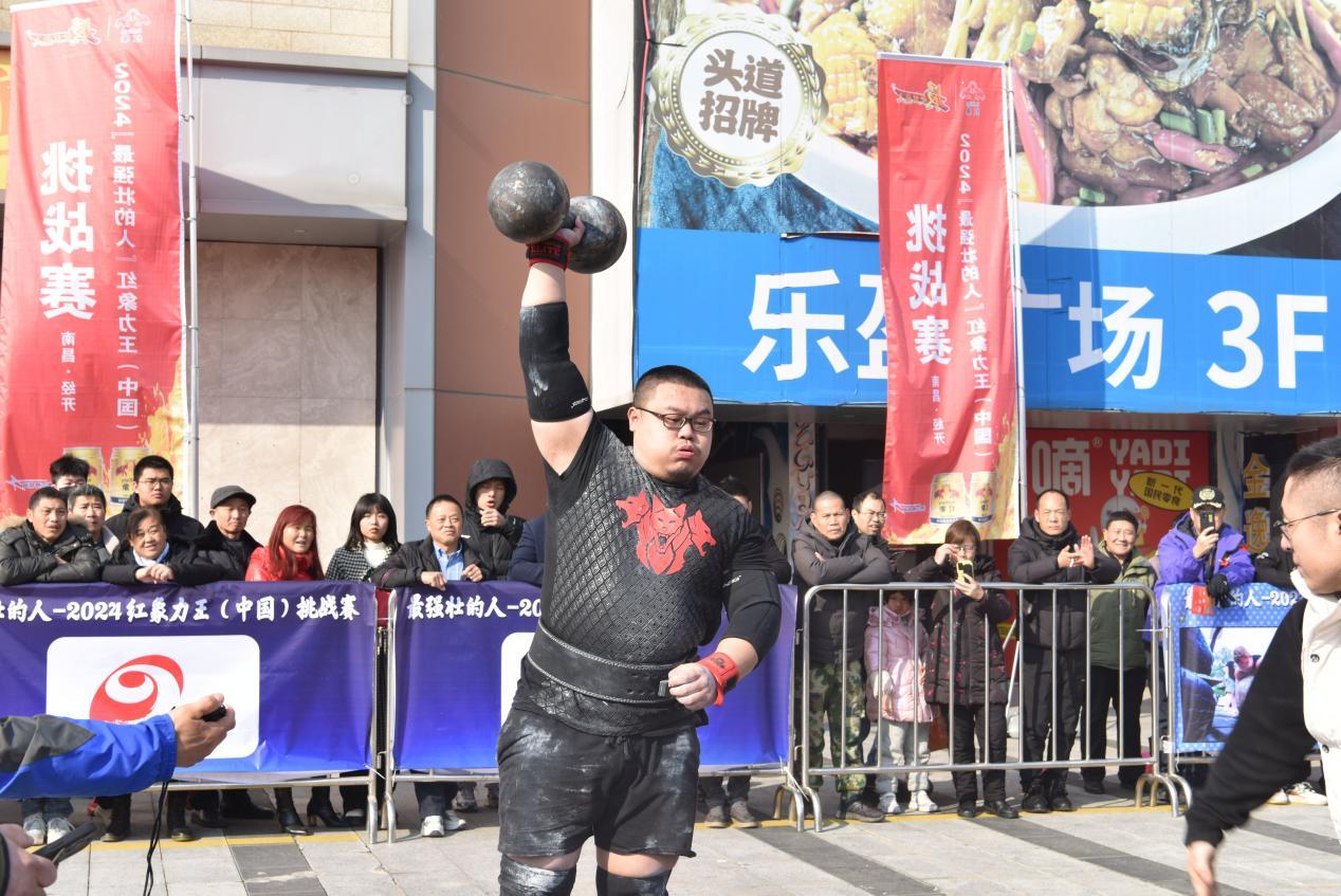 选手进行单手托举65kg哑铃比赛