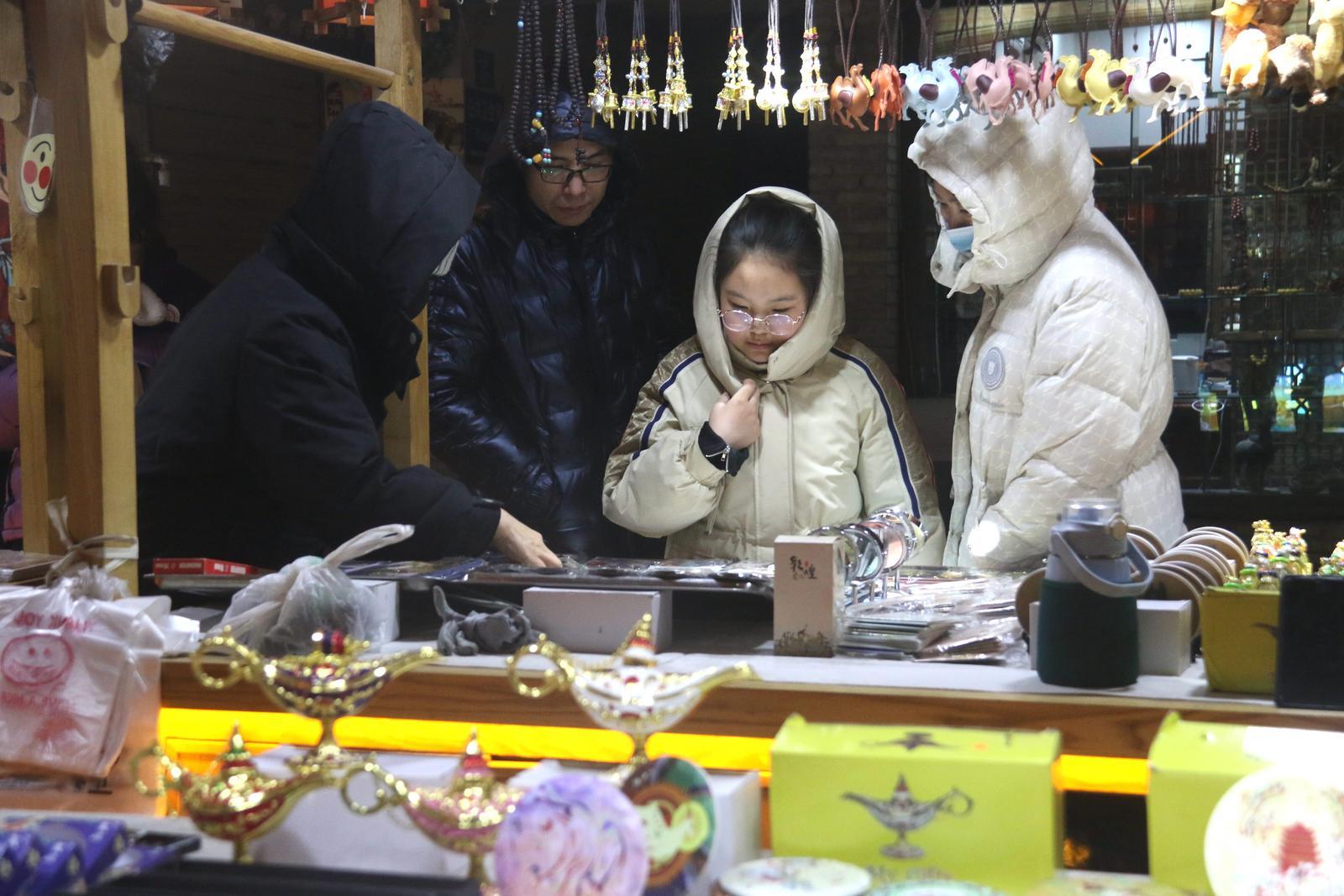 游客在敦煌夜市选购特色旅游工艺品