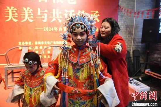 1月31日，老师在为“小演员”化妆换戏服。刘娟 摄