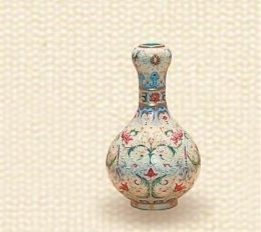洋彩西蕃莲纹蒜头瓶 清·乾隆 故宫博物院藏 高18厘米,口径2.6厘米, 足径5.5厘米 洋彩用料与瓷胎珐琅器相同,其特点是运用西洋绘画技法与纹饰。此器满绘西洋花卉,以西蕃莲花为主,用珐琅白料表现花叶藤蔓明暗,并以金彩勾绘,色彩华丽而柔和,纹饰繁复而纤细,与18世纪欧洲流行的洛可可繁复华丽的宫廷装饰艺术风格相符。