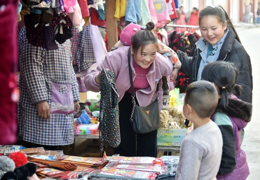2021年1月22日，巴木玉布木在当地集镇一家服装店给孩子挑选衣服。新华社记者 周科 摄