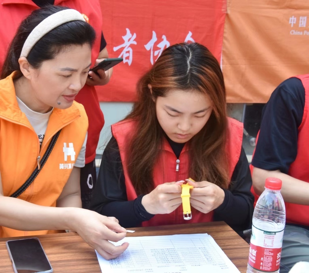 图为刘艺锦参加“防走失黄手环”行动发放现场