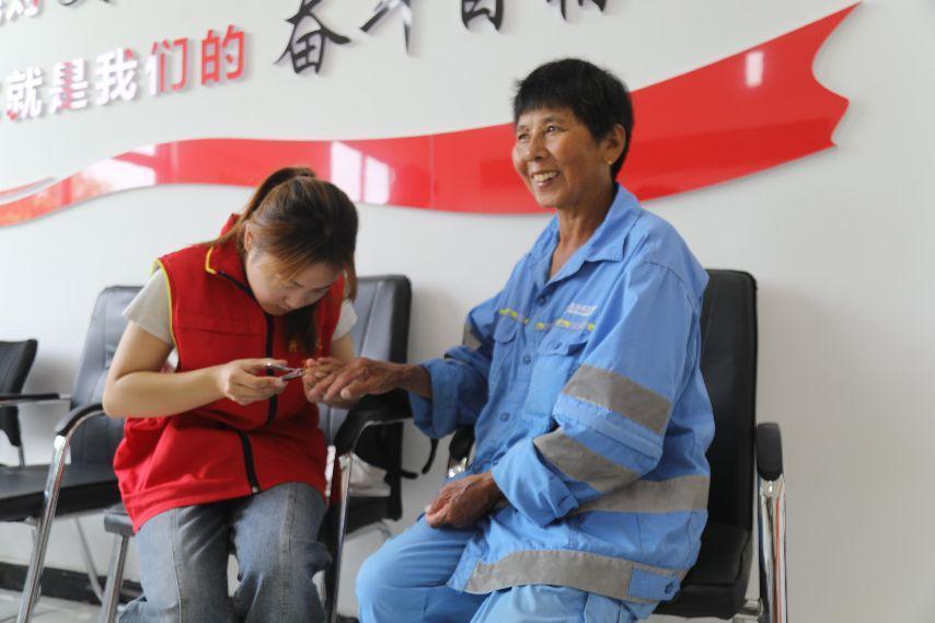 图为刘艺锦为环卫工人剪指甲