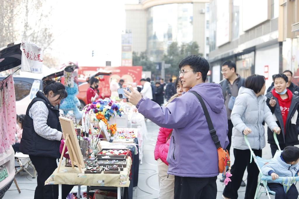 （市民在非遗文化展示区在打卡拍照留念。）