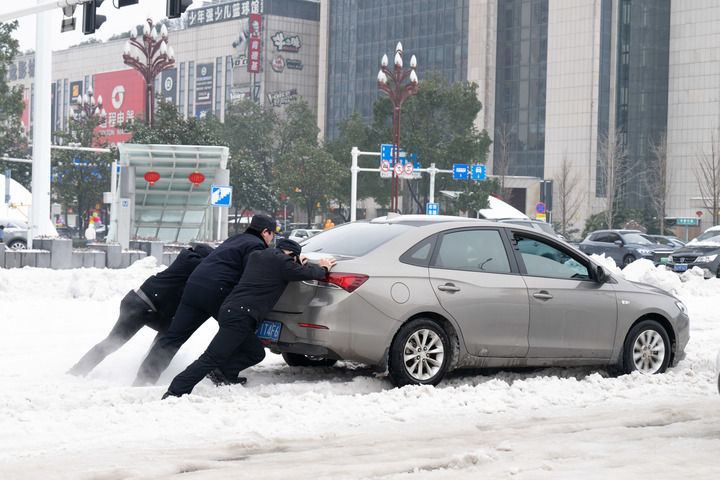 2月4日，在湖南常德火车站，武陵公安分局站前派出所民辅警帮助打滑车辆脱困。新华社发（蔡文龙摄）