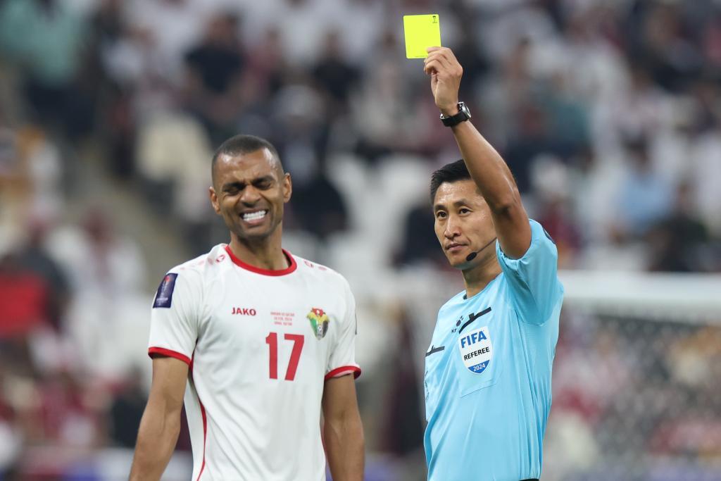 2月10日，决赛主裁判马宁（右）向约旦队球员阿亚林出示黄牌。新华社记者 丁汀 摄
