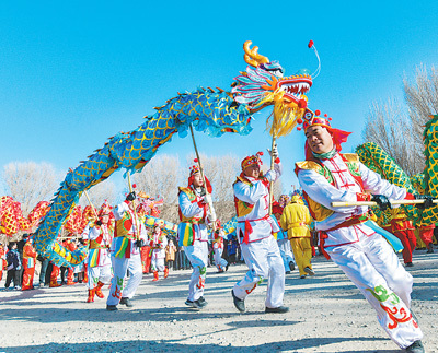 2月14日，甘肃省敦煌市社火队在白马塔景区进行舞龙表演。王斌银　摄（影像中国）