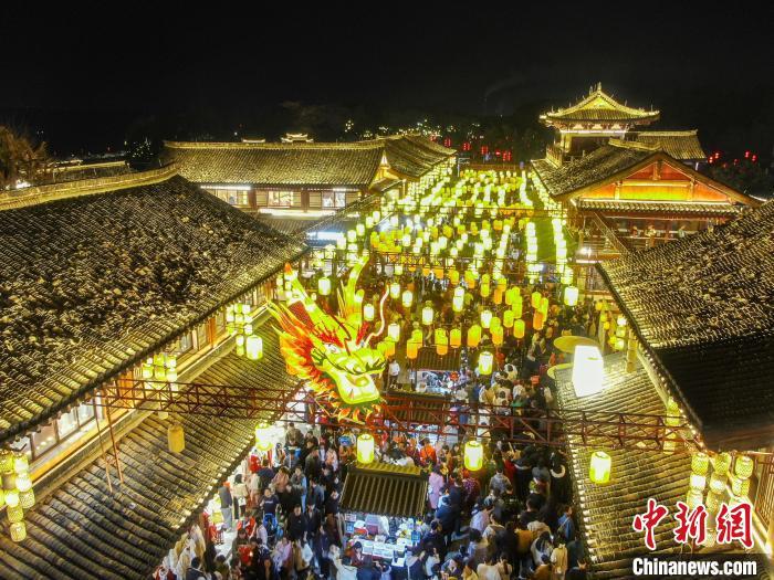 图为航拍古街区的一个长龙造型花灯，众多游客在古街区内观光游玩。刘力鑫 摄