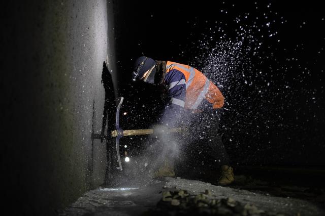 2月1日,在西罗奇岭二号隧道内,盘古线路车间的工人刘泊序在进行破冰