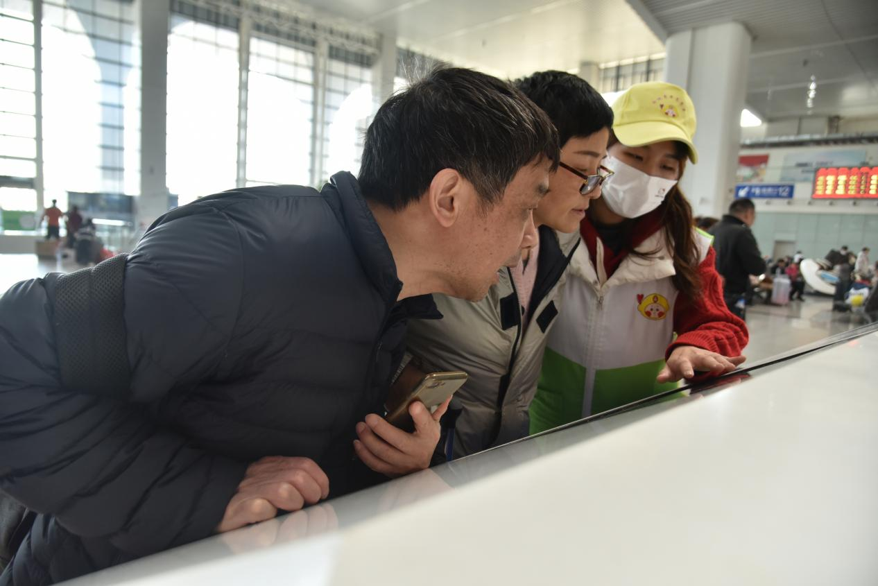 福州火车站青年志愿者帮助旅客查询乘车信息。江曲 图