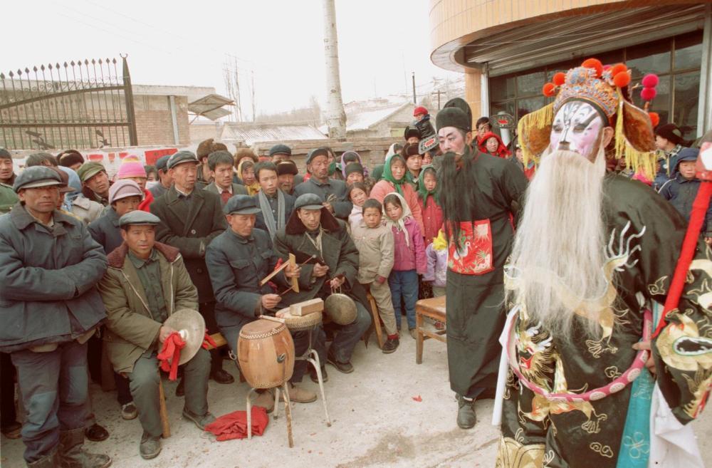 1997年春节假期期间，宁夏固原县什字路镇社火队在集市上表演秦腔折子戏。