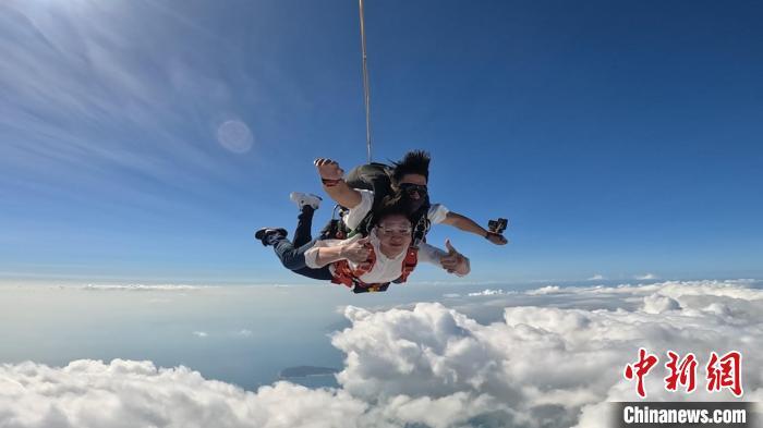 2024年2月，游客在海南三亚体验高空跳伞。　(三亚塔赫极限运动俱乐部有限公司供图)