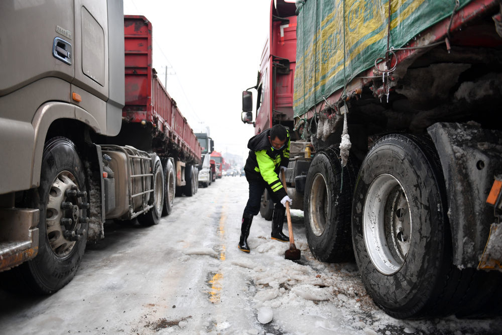 2月4日，交警在湖南省临湘市羊楼司镇协助货车车主除冰。新华社记者陈振海摄