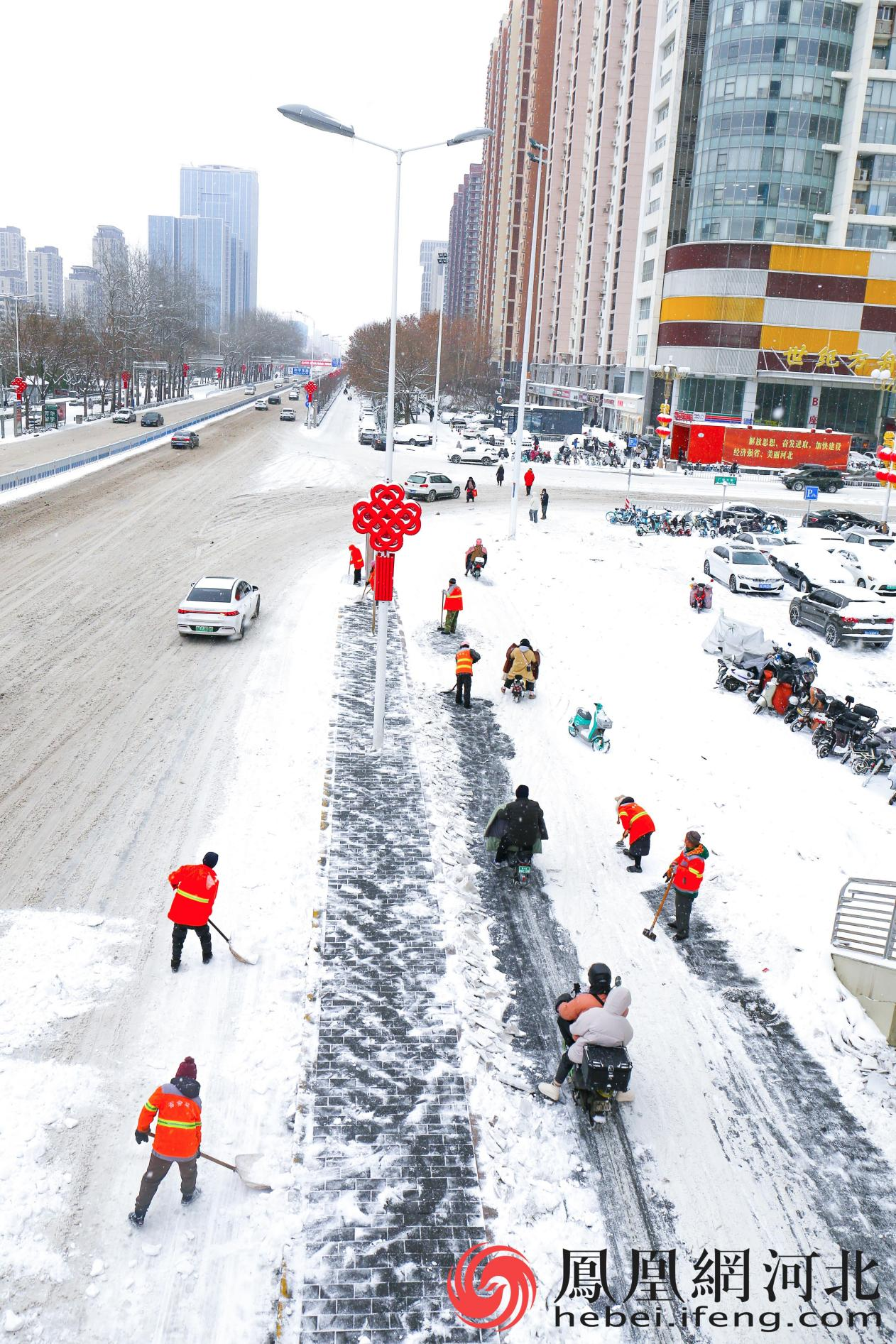 雪中的环卫工人与高高挂起的中国结一样，是街道上最靓丽的风景线。