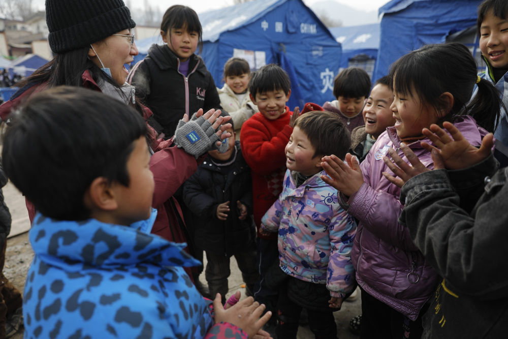 2023年12月22日，在积石山县大河家镇大河村安置点，心理治疗师胡瑾娅带着小朋友们唱歌。