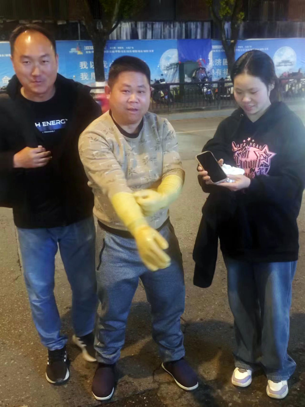 2月17日晚，从污水坑里捞出手机后，甘肃游客陈先生（左一）夫妇与景德镇市政工作人员合影。