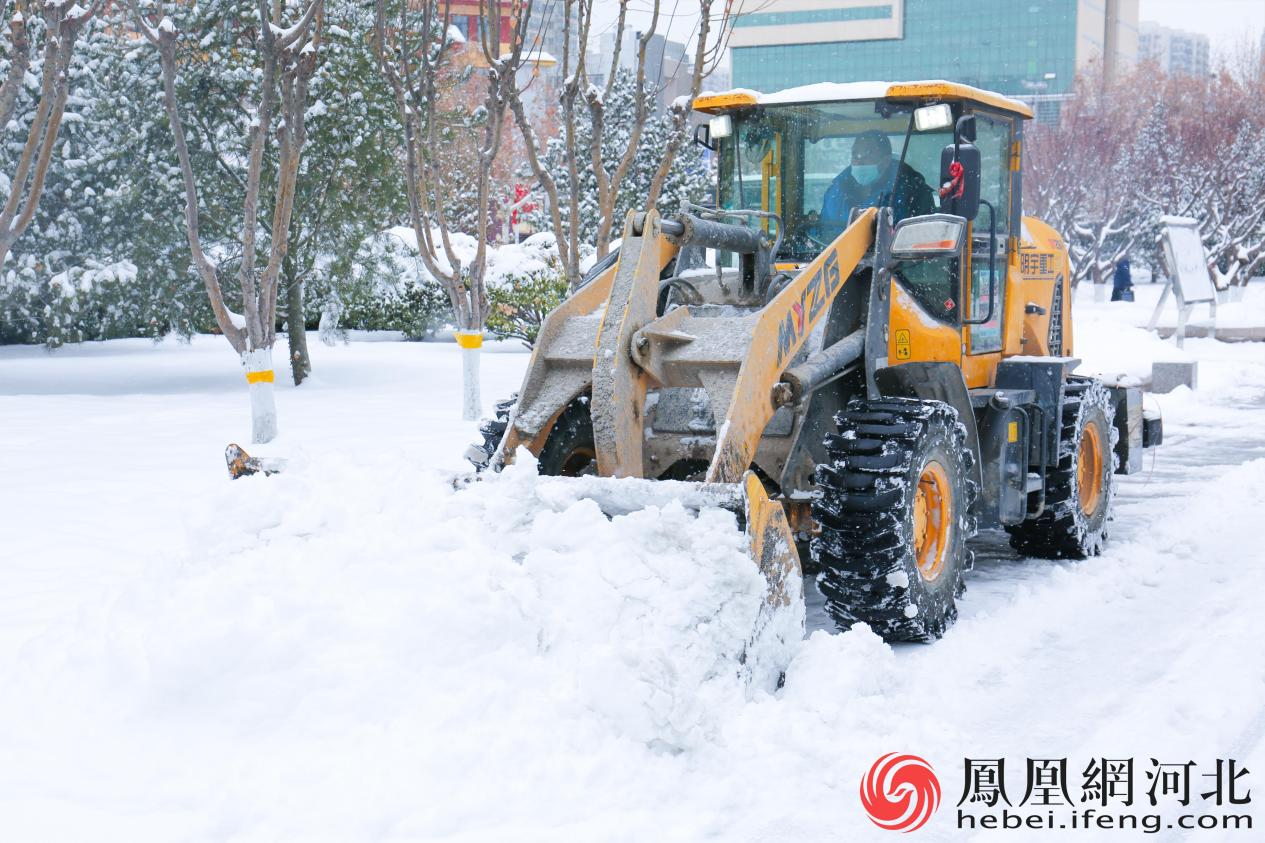 河北博物院旁的便道上，工人师傅开着推土机清理积雪。