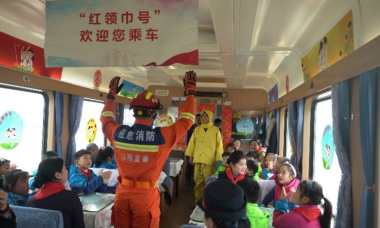 2月20日，宜春消防救援支队在列车上给少先队员们展示消防员服饰及功能。（李达伟 摄）