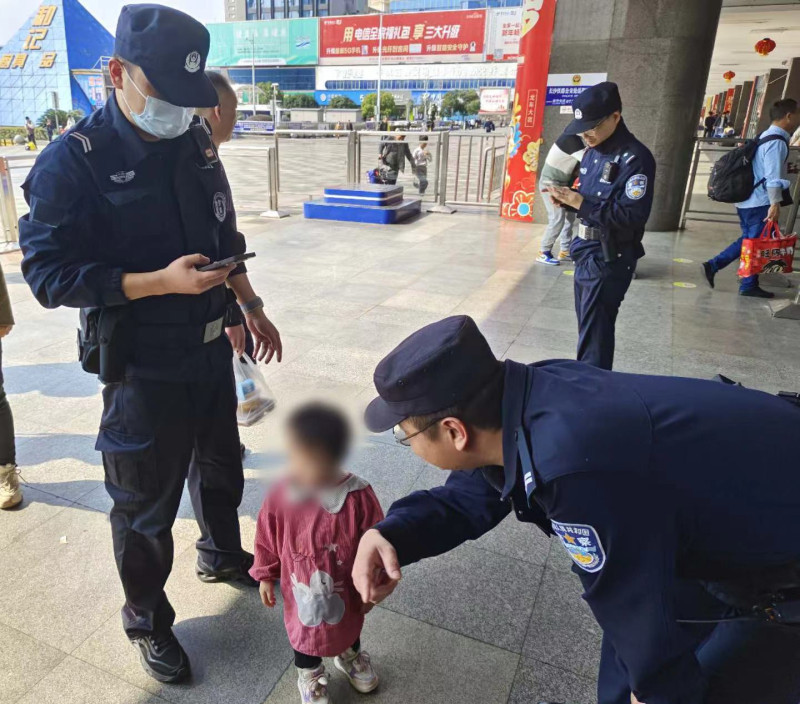 3岁小孩独自在进站口旁，民警帮其寻找家人。