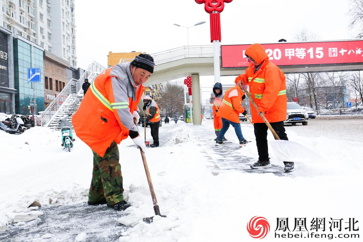 环卫工人们清理路面积雪，保障市民出行安全。