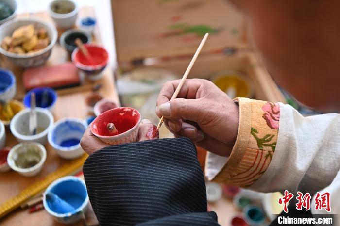 交巴加布的唐卡艺术之路始于童年。在父亲的熏陶下，他从小就对唐卡艺术产生了浓厚的兴趣。他不仅继承其父亲九麦的画风特点，还不断向其他画师求教学习，揣摩画技，使自己的技艺更上一层楼。2024年2月，交巴加布在个人工作室内调绘制唐卡所需的颜料。九美旦增　摄
