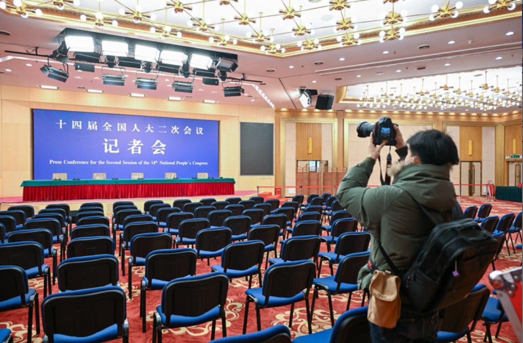 2月27日，一名记者在两会新闻中心记者会现场拍摄。当日，在2024年全国两会即将召开之际，设在北京西长安街北侧梅地亚中心的两会新闻中心正式启用。新华社记者 李鑫 摄