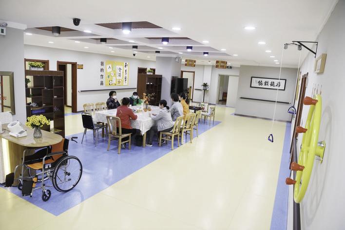 在养老照料中心内，工作人员正在陪伴老人们聊天。
