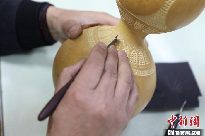 2月29日，闫继盈正在葫芦上进行雕刻操作。刘延岭 摄