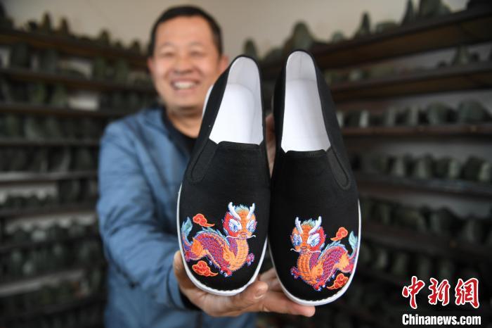 2月29日，杨西利展示做好的龙年元素布鞋。崔贤飞 摄