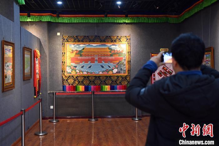 图为游客在唐卡小镇一展厅内参观展出的唐卡作品。九美旦增 摄