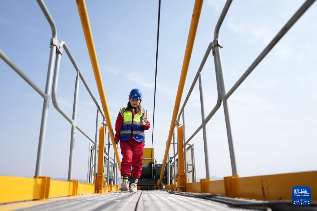 3月6日，在中建三局兰州大学榆中校区项目建设工地，王甜甜从塔吊尾部走过。