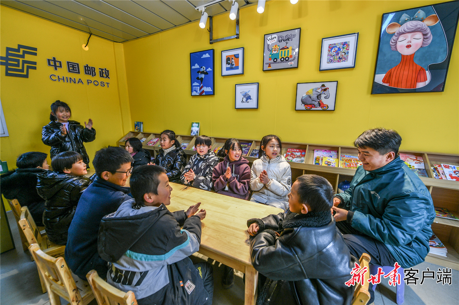 大河村广场上中国邮政的爱心驿站内,工作人员和孩子们一起开展阅读活动。新甘肃·甘肃日报记者 郁婕 摄