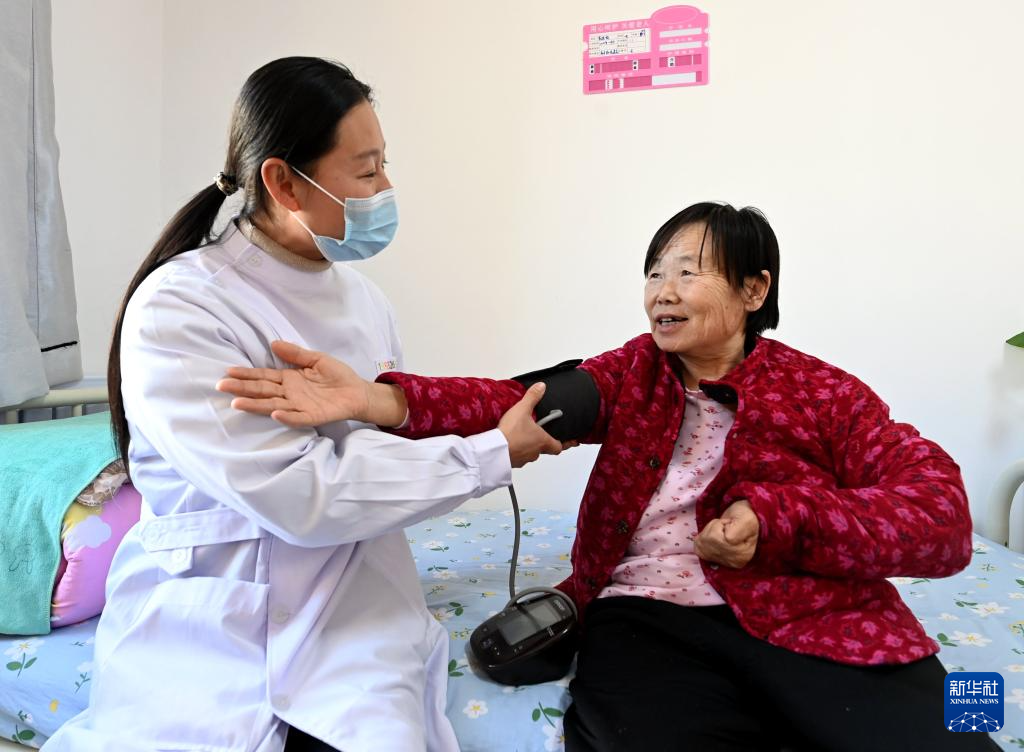 2月29日，在香河县安平镇运河新村医养中心，医护人员为老人测量血压。
