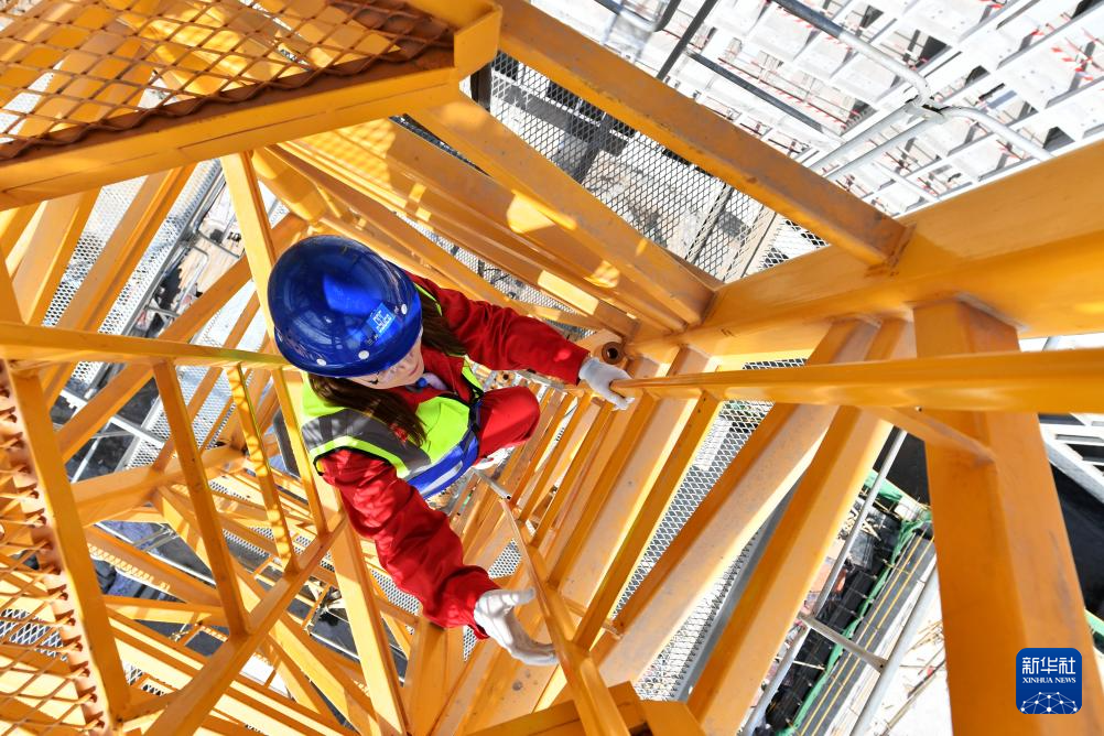 3月6日，在中建三局兰州大学榆中校区项目建设工地，王甜甜在攀爬塔吊准备作业。