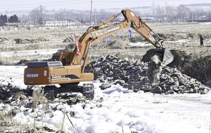 在衬砌明渠作业现场，大型机械繁忙施工，项目建设有序推进。 张扬 摄