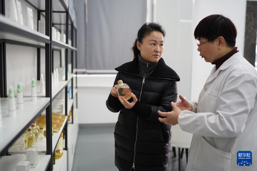明经华（左）在位于江西赣州市章贡区的赣州哈克生物科技有限公司调研油茶深加工产业（2023年2月24日摄）。新华社记者 周密 摄
