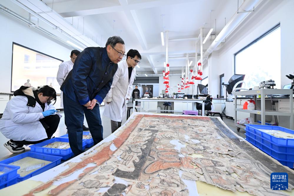 在云冈研究院壁画文物修复室，杭侃（前）和同事交流壁画修复方案（2024年2月25日摄）。新华社记者 詹彦 摄