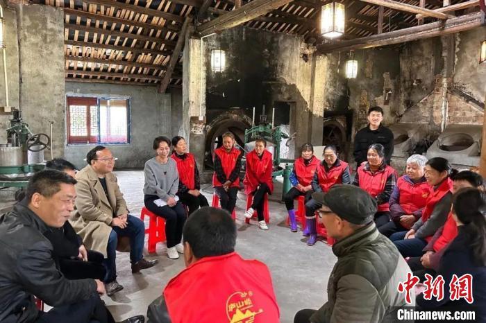图为全国人大代表、江西省九江鑫城纺织有限公司职工熊晓梅在和群众沟通交流。(资料图)受访者供图