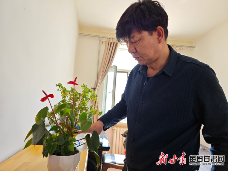 柳常财正在悉心浇灌宿舍的花