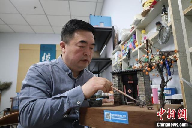 图为王伟为老式门楼微缩景观模型上色。徐鹏璐 摄