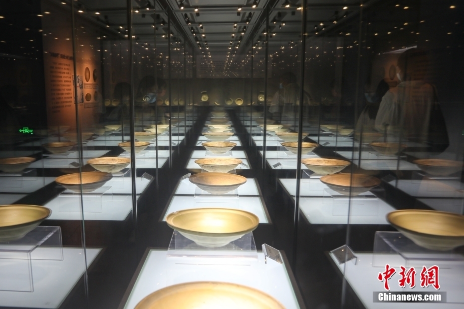 在位于江西景德镇的中国陶瓷博物馆“丝路遗珍”—中国古代外销瓷展展厅内，游客在观看展出的元代青釉盘。中新社记者 刘力鑫 摄