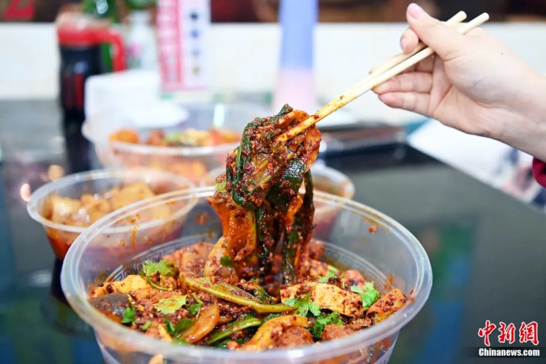 3月14日,甘肃天水,游客品尝麻辣烫。近日,甘肃天水麻辣烫在网络平台火爆,吸引全国各地众多游客前来品尝。九美旦增 摄