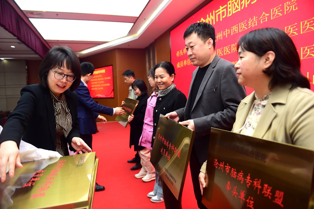 沧州市卫健委副主任岳建玲（左）为沧州市脑病专科联盟签成员单位代表授牌。