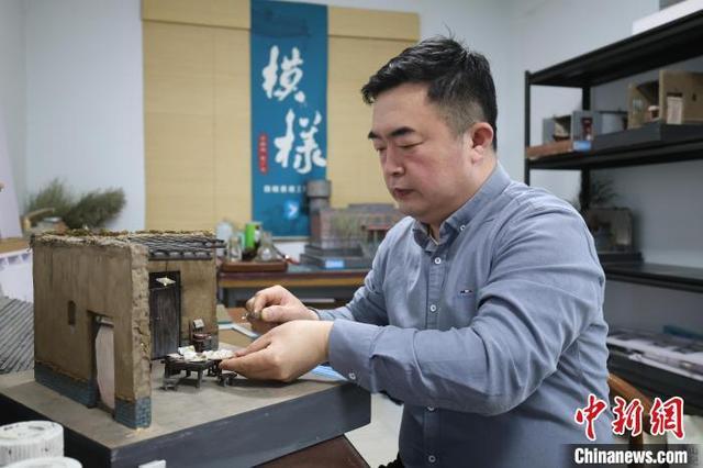 图为王伟正在制作老式民居微观景观模型。徐鹏璐 摄