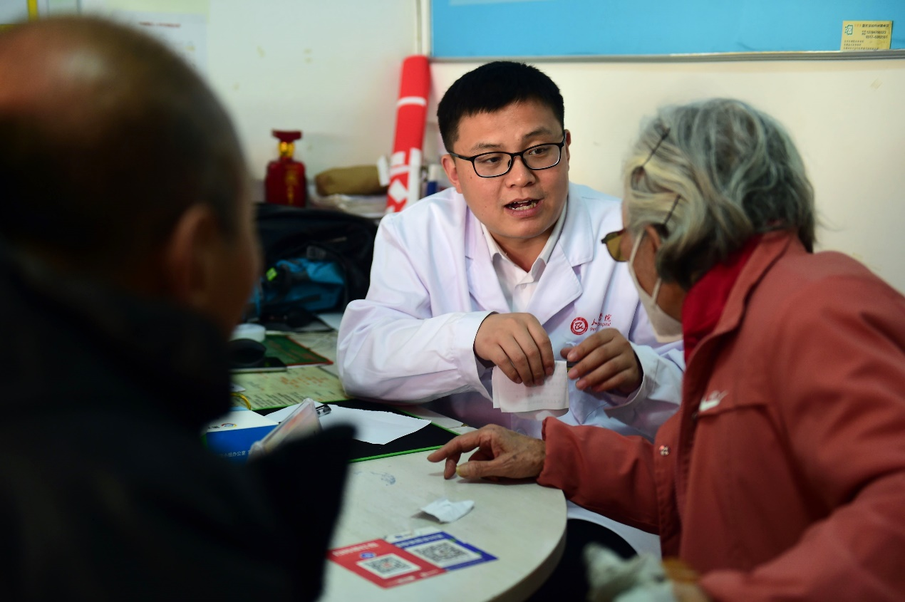 神经内科医生刘全亮向居民了解身体状况。