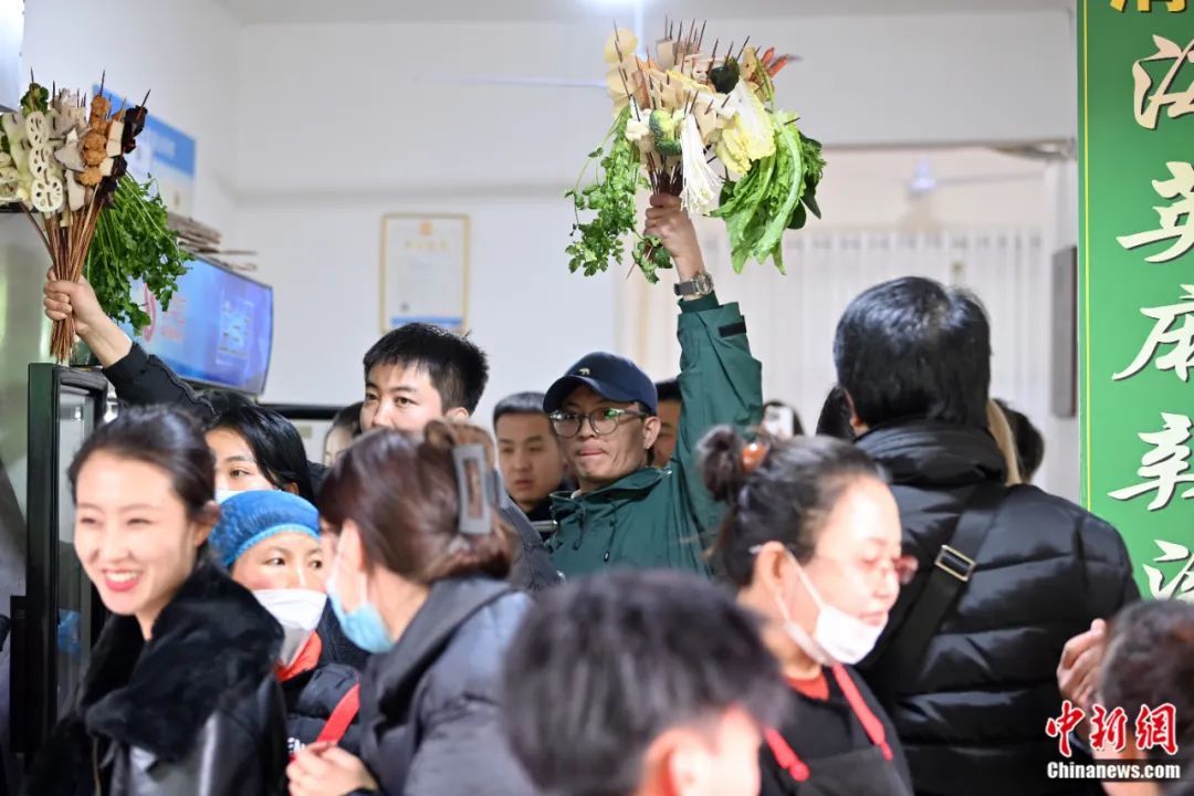 3月14日,甘肃天水,游客手举挑选的麻辣烫食材“蔬菜花束”。九美旦增 摄