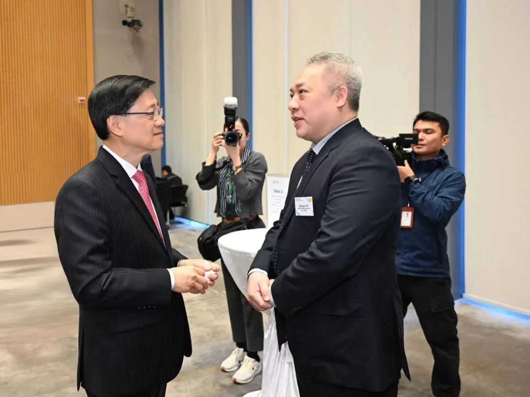 图:香港特区行政长官李家超(左)与华大智造总裁余德健(右)交流双方合作